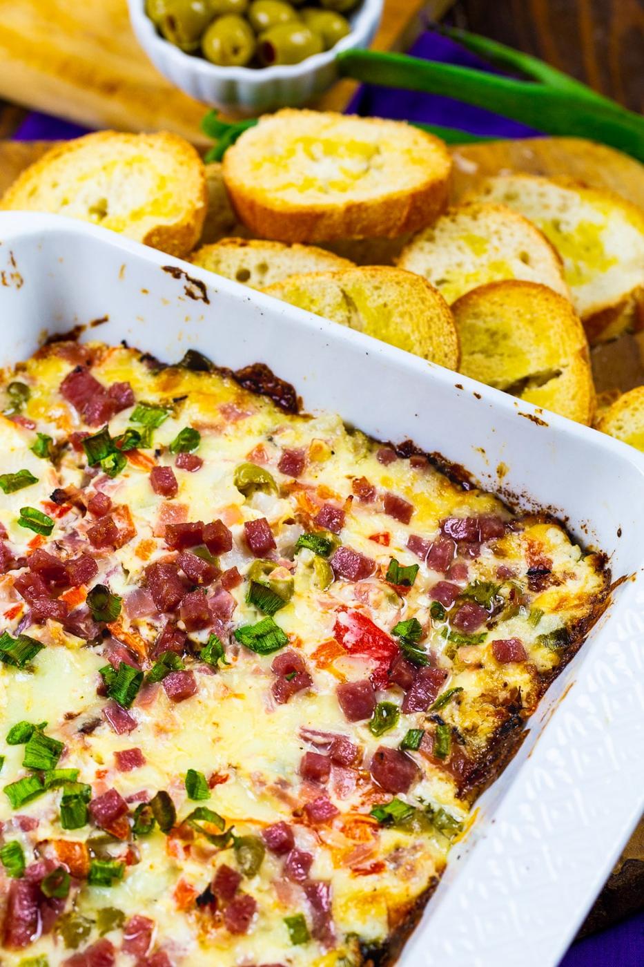 Hot Muffaletta Dip in white baking dish.