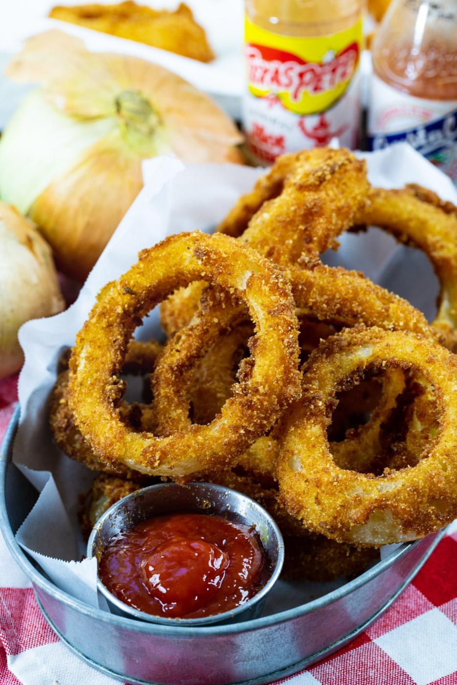 Hot Sauce Marinated Onion Rings in a serving dish with ketchup.