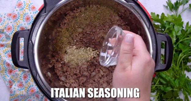 Adding Italian seasoning.