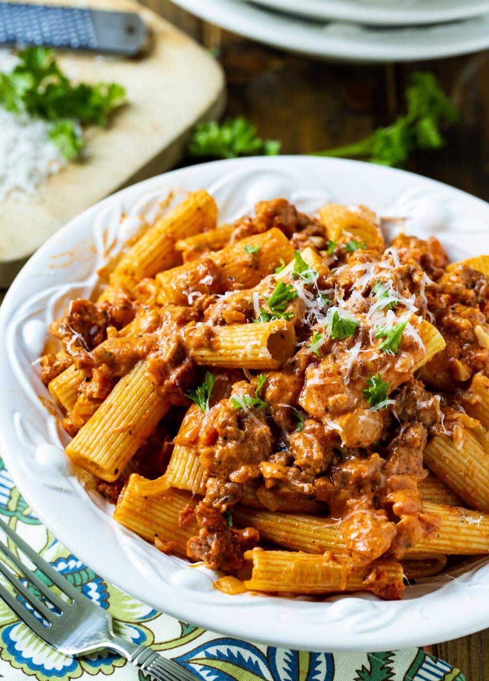 Pasta coated in sauce in serving bowl.
