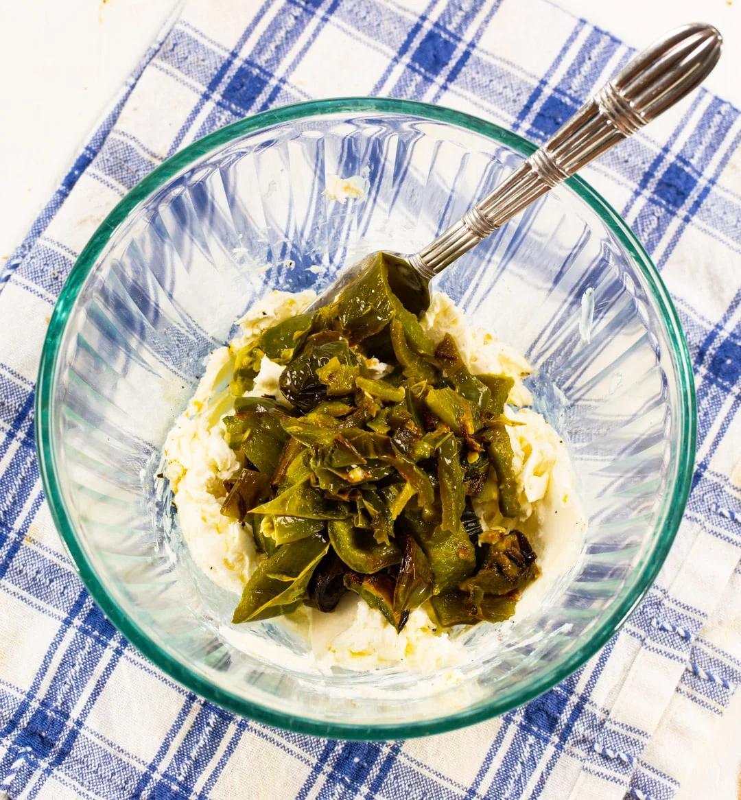 Cream cheese and roasted jalapenos in mixing bowl.