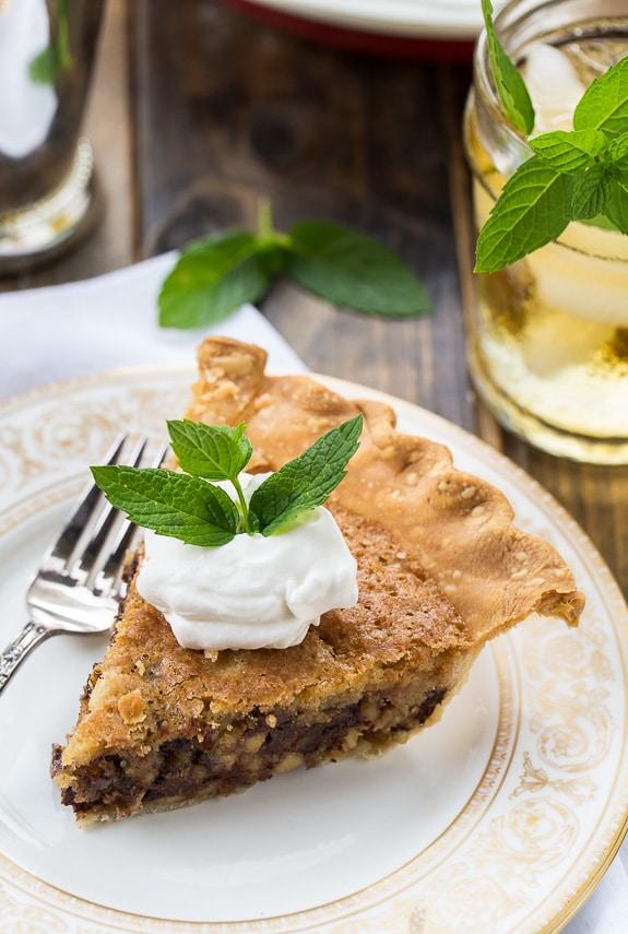 Kentucky Derby Pie has a gooey chocolate and walnut filling with a splash of bourbon. Topped with bourbon whipped cream for a truly delicious southern dessert.