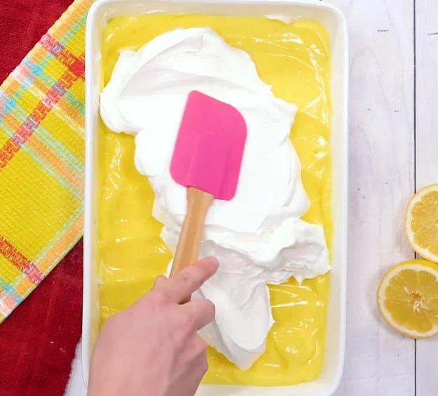 Spreading Cool Whip on top.