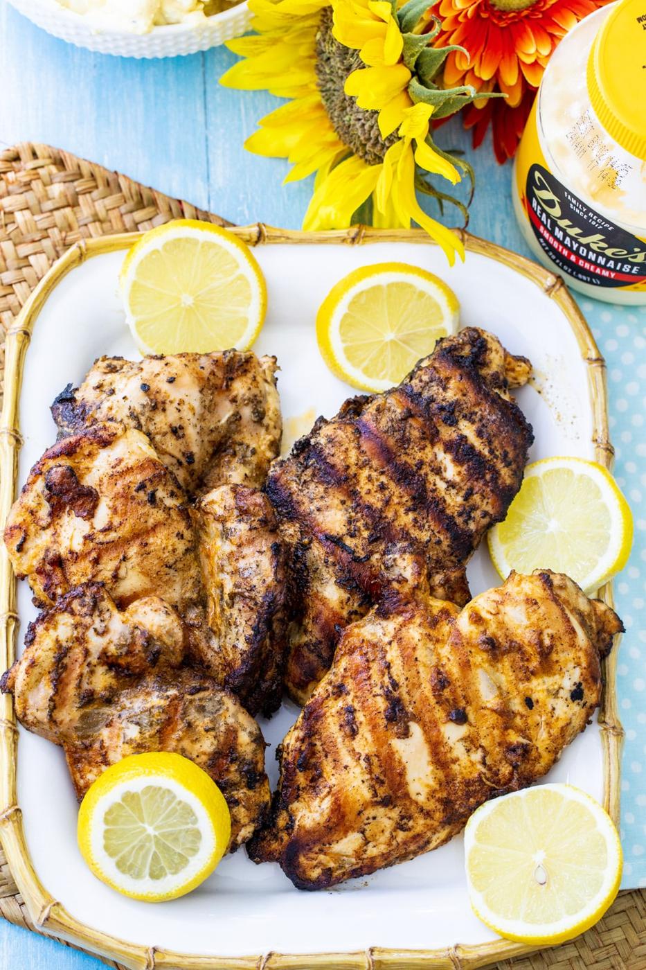 Mayonnaise Marinated Grilled Chicken on a serving platter with lemon slices and a jar of mayonnaise.
