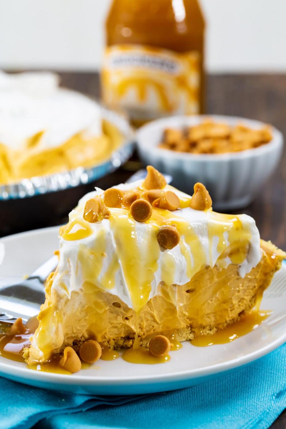 No-Bake Butterscotch Pie on plate with jar of butterscotch topping in background.