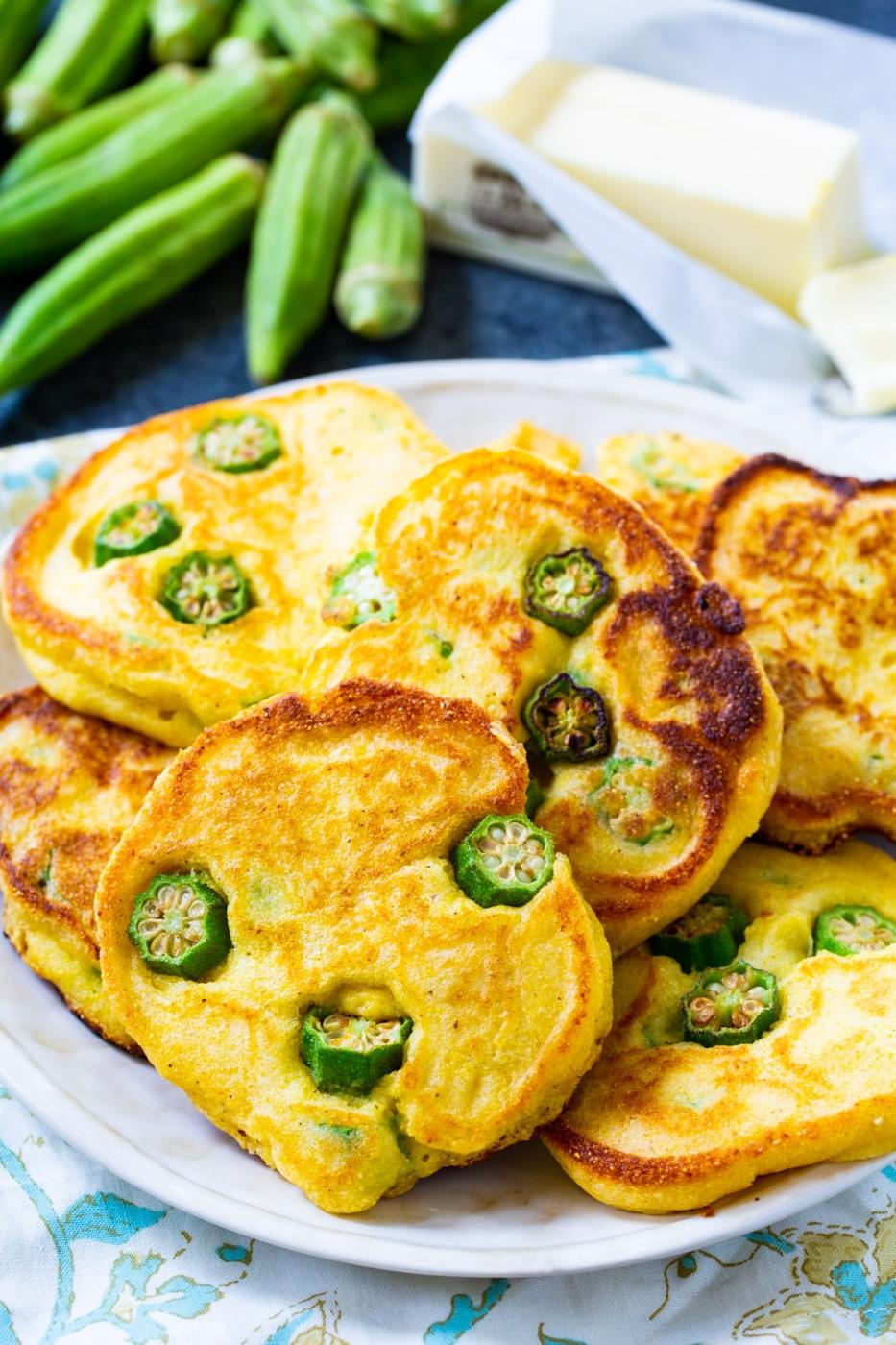 Hoecakes with okra on plate with okra in background.