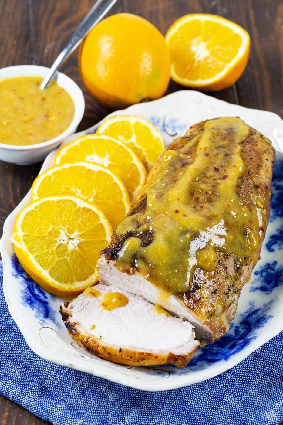 Pork Loin with orange glaze on a serving platter with orange slices.