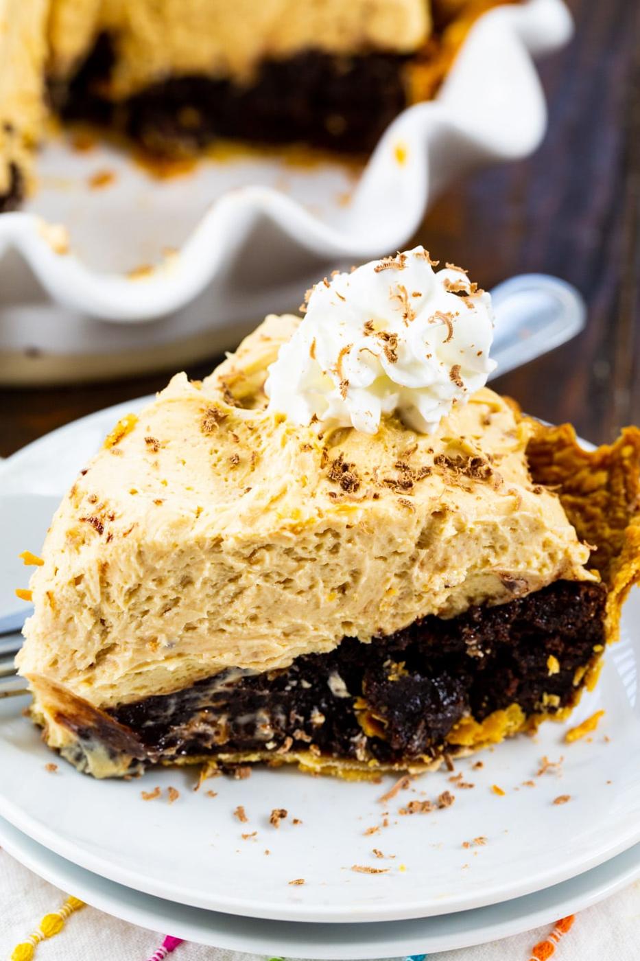 Peanut Butter Brownie Pie slice topped with whipped cream on plate.