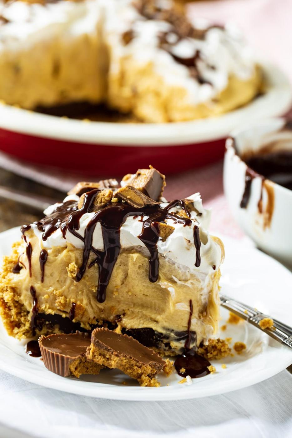 Slice of Peanut Butter Pie on plate with rest of pie in background.