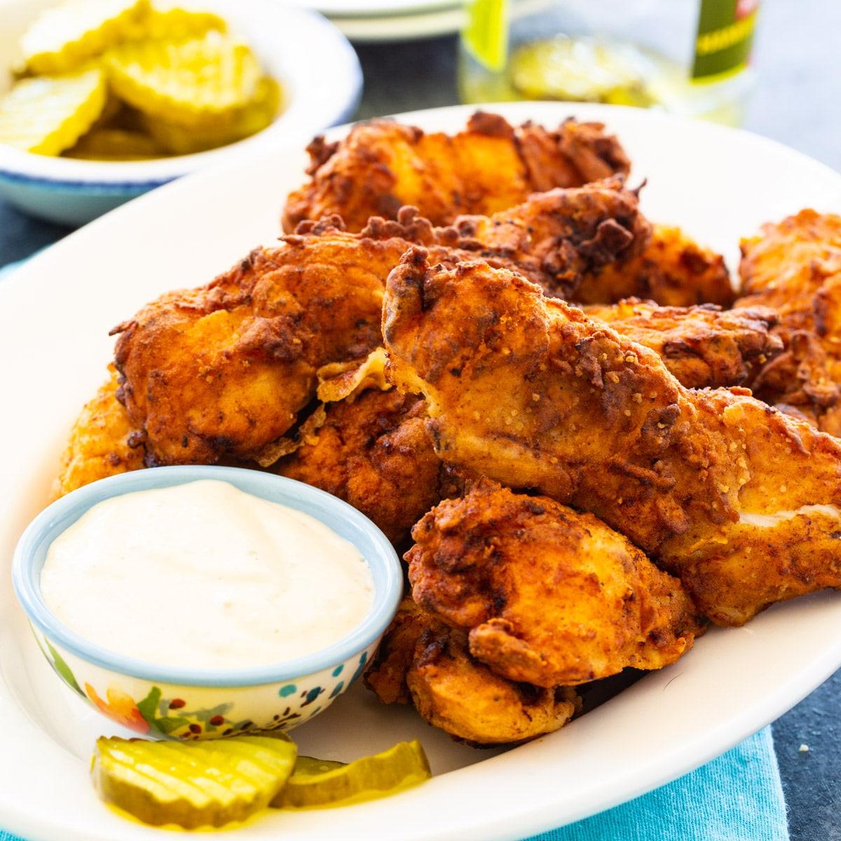 Pickle-Brined Chicken Tenders on plate with small bowl of dipping sauce.