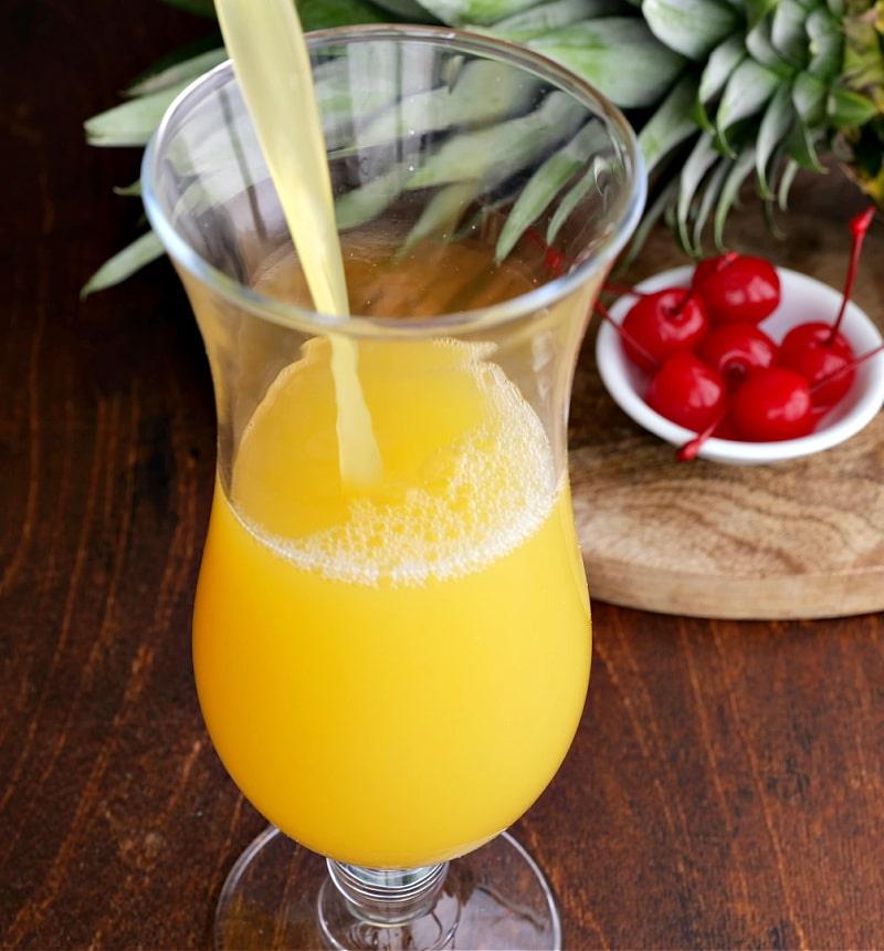 Pineapple mixture poured into hurricane glass.