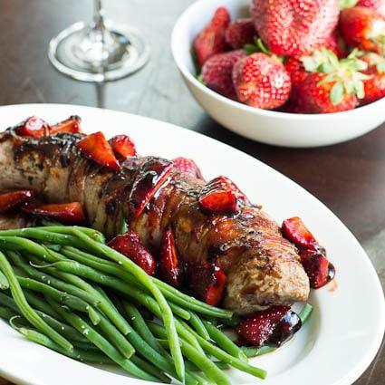 Pork Tenderloin with Strawberries on a white platter with green beans.