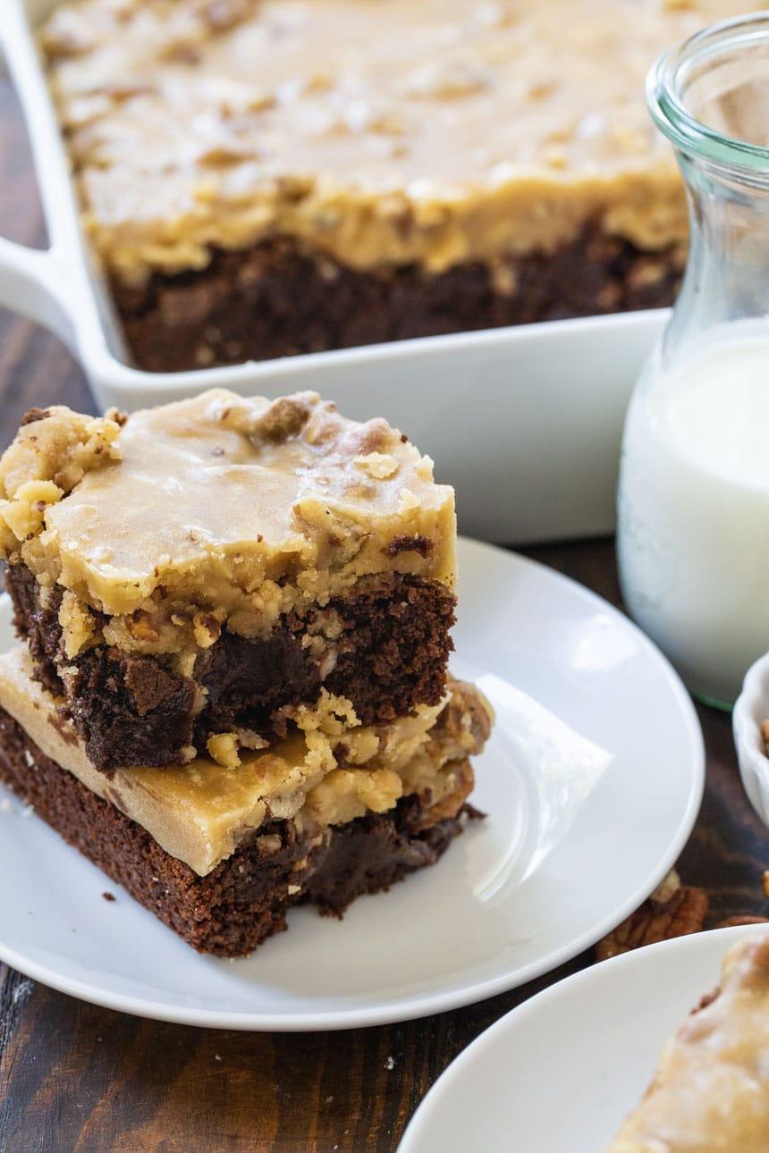 Two Brownies stacked on a white plate.