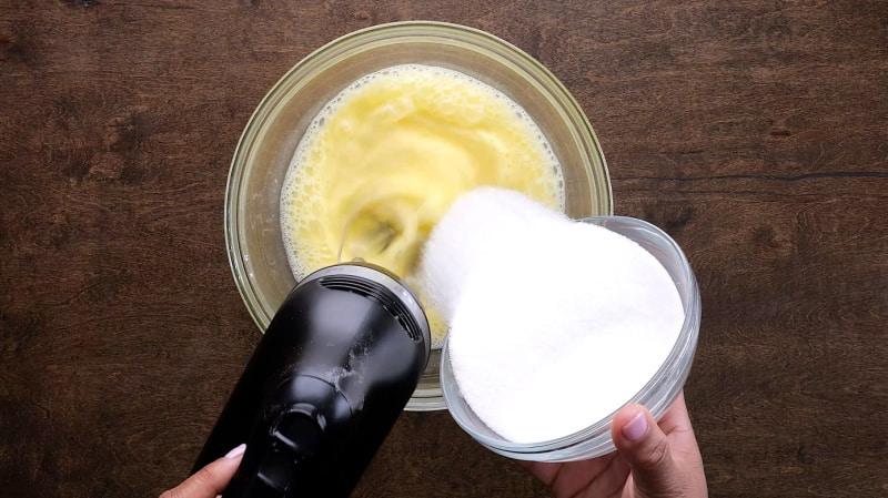Adding sugar into eggs.