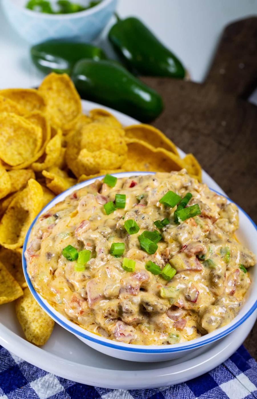 Sausage Pimento Cheese Dip in a bowl surrounded by corn chips.