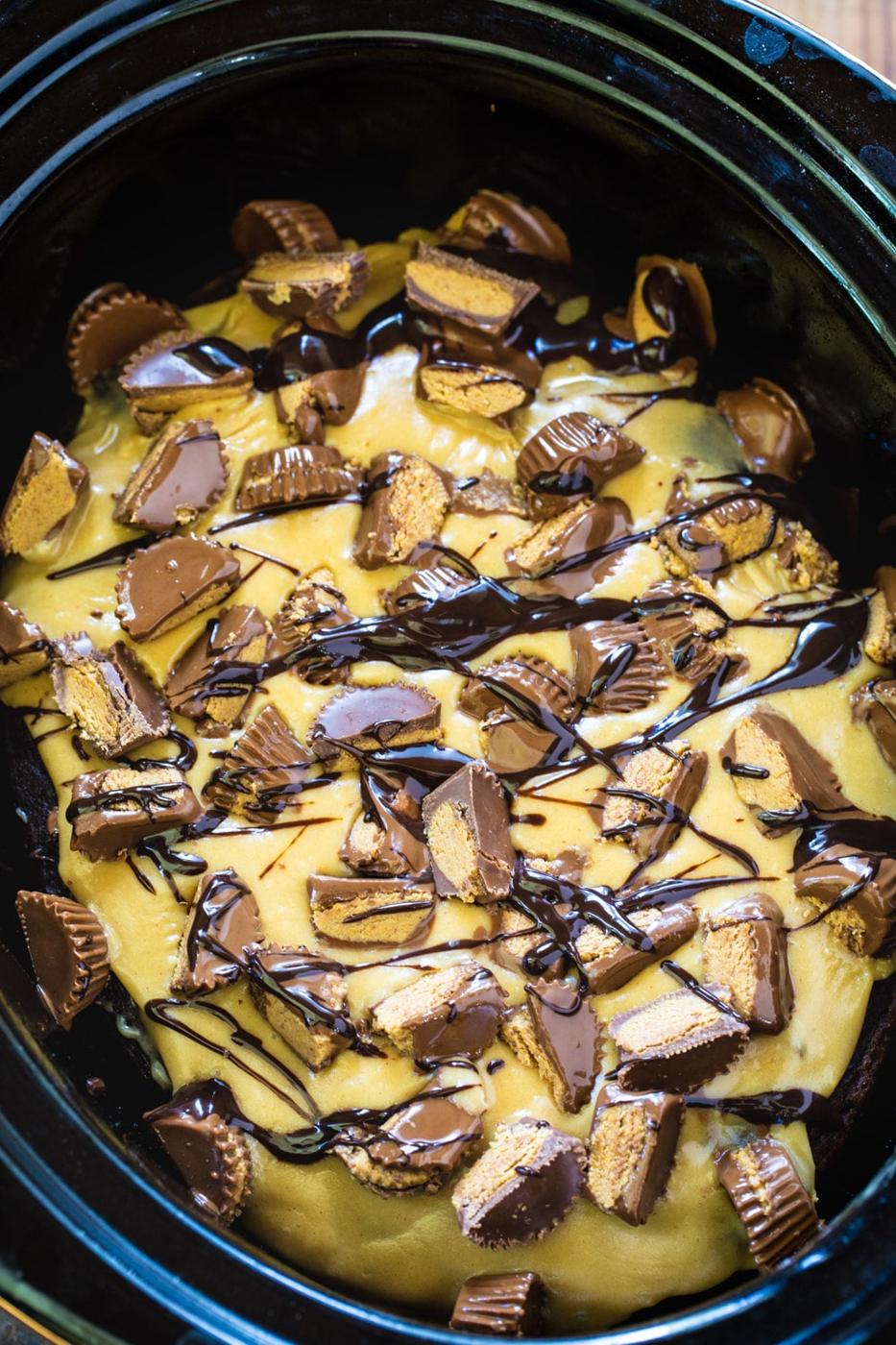 Slow Cooker Chocolate Peanut Butter Cake topped with chopped peanut butter cups.