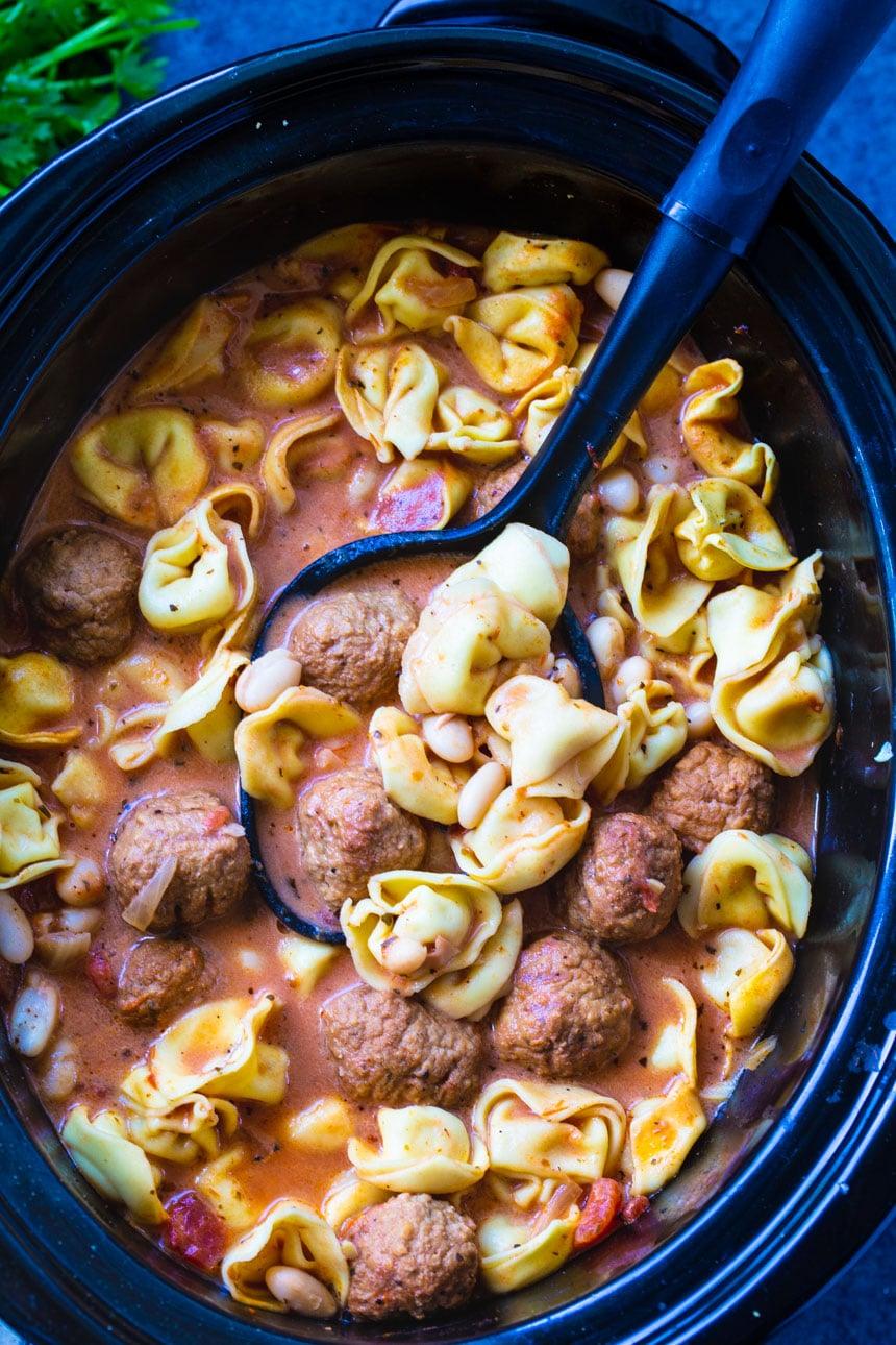Spoon scopping soup in slow cooker.