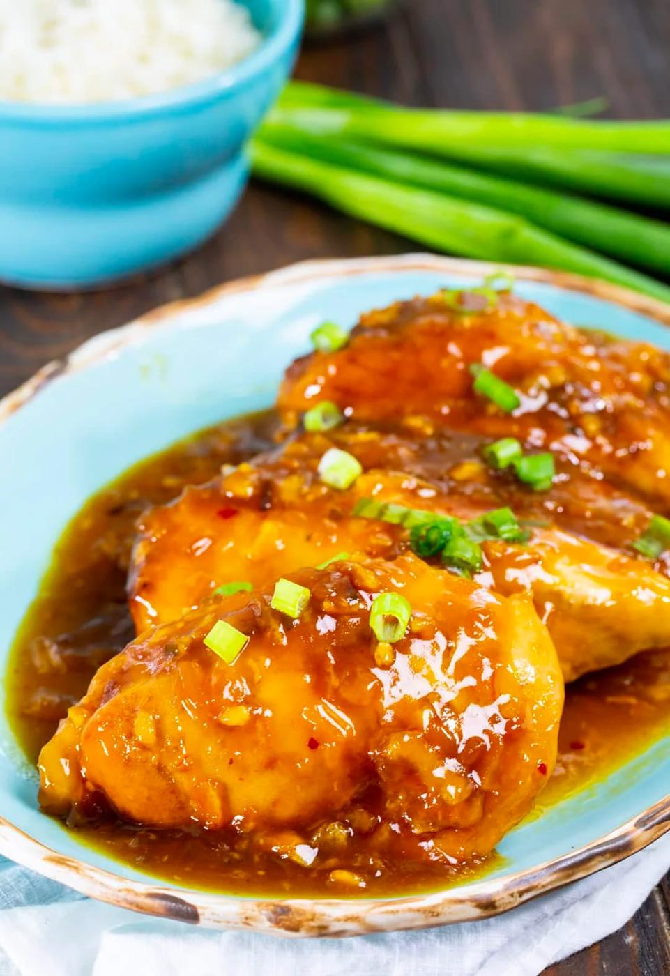 Slow Cooker Orange Chicken on serving plate and bowl full of rice.