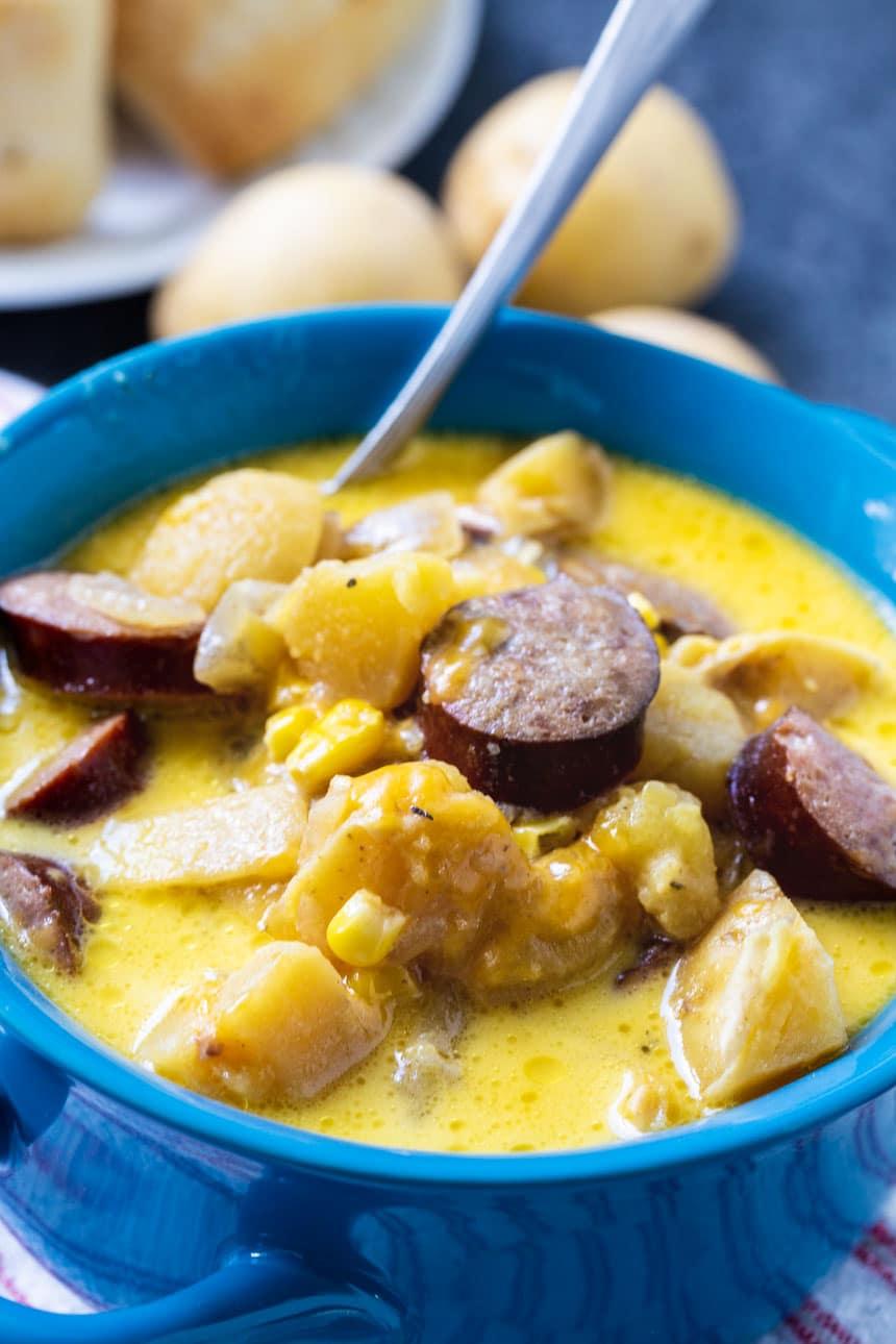 Slow Cooker Chowder in a blue bowl with a spoon.