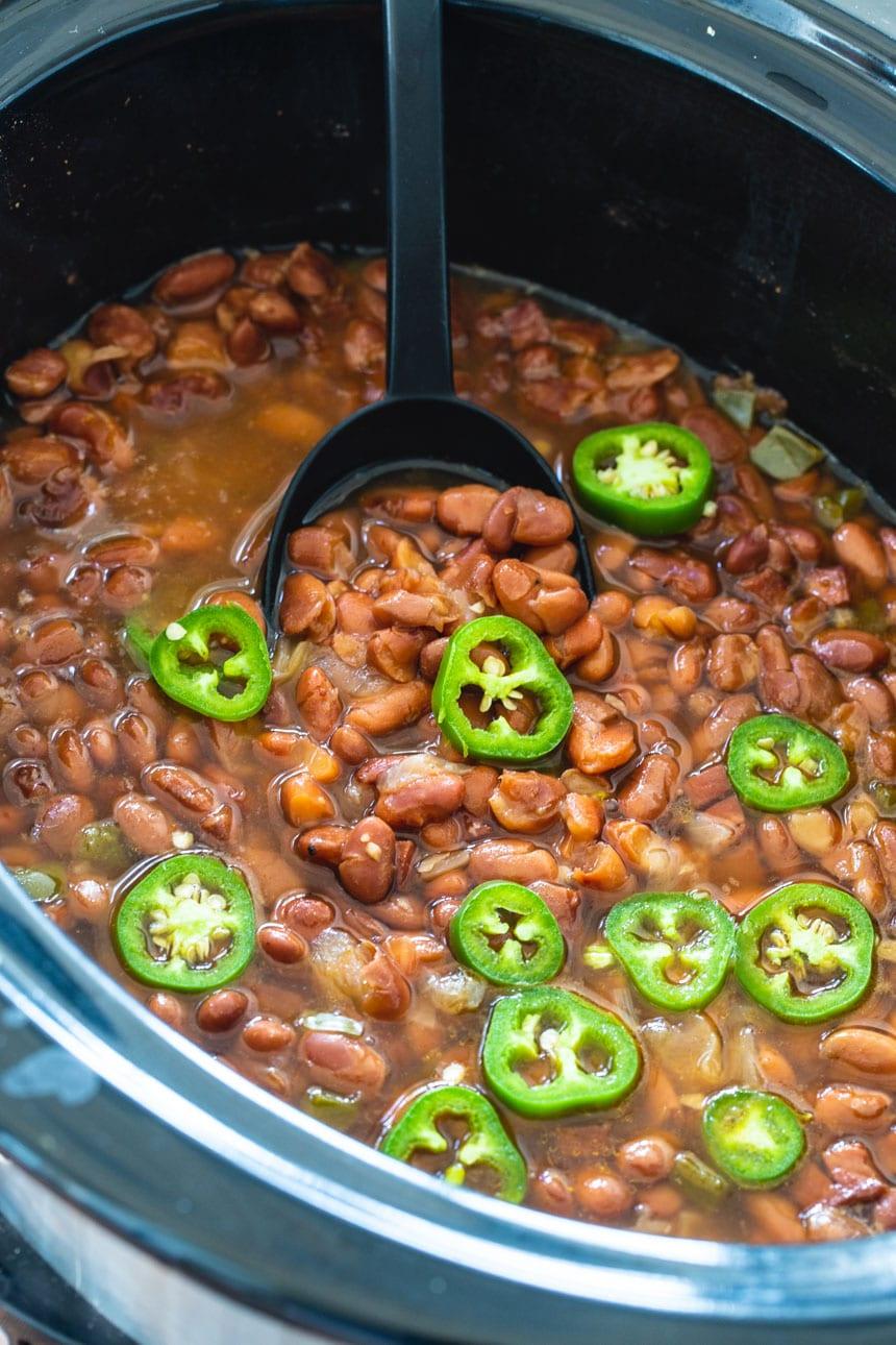 Spicy Pinto Beans in a black crock pot.