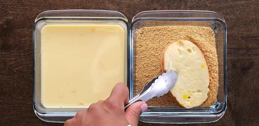 Dipping bread in graham cracker crumbs.