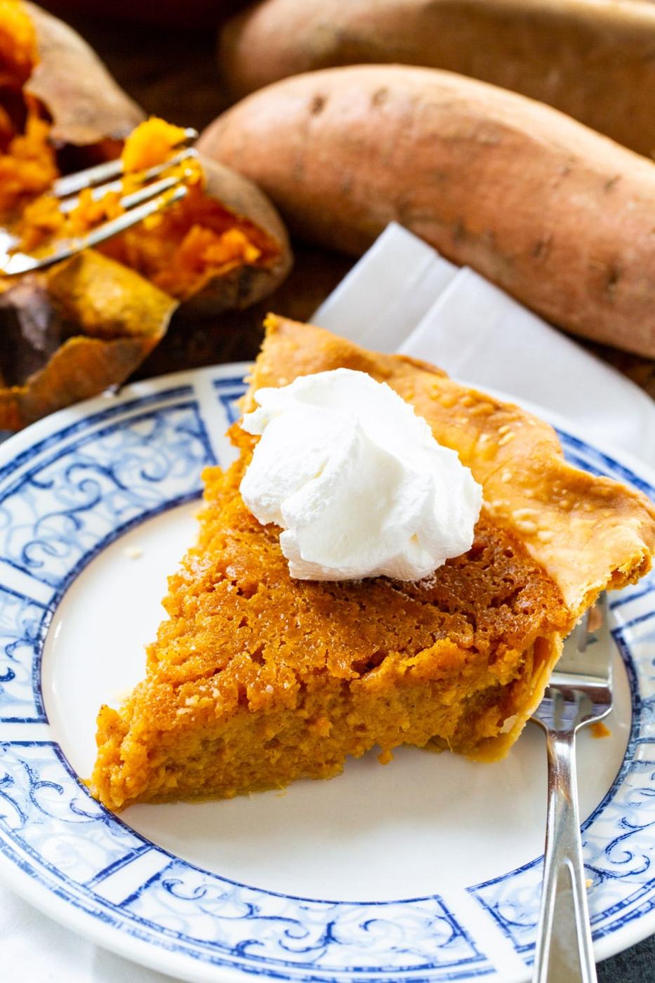 Slice of pie on a plate with sweet potatoes in background.