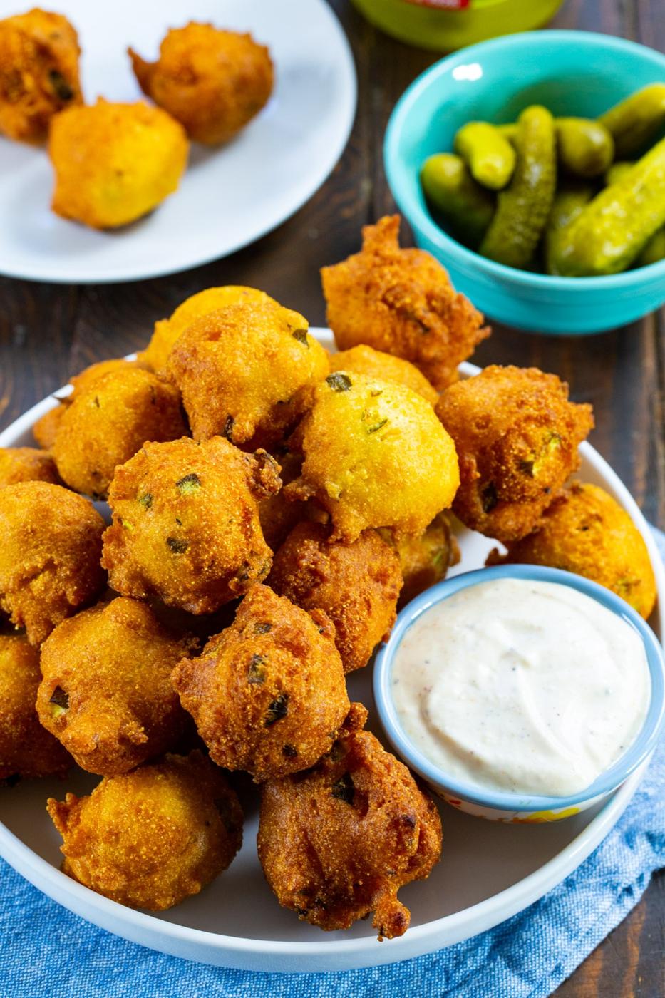 Plate of hush puppies and bowl of pickles.