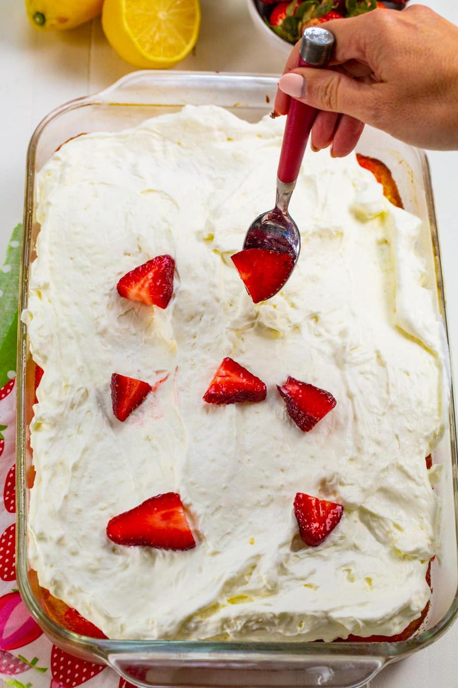 Spooning strawberries on top.