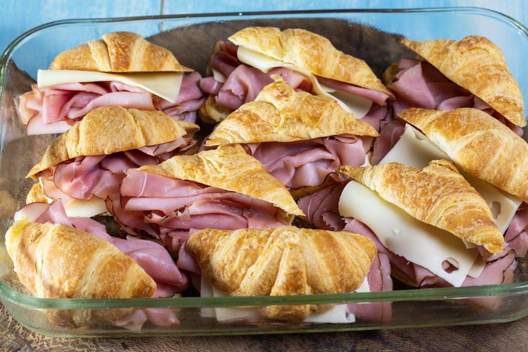 Ham and cheese stuffed croissants in baking dish.