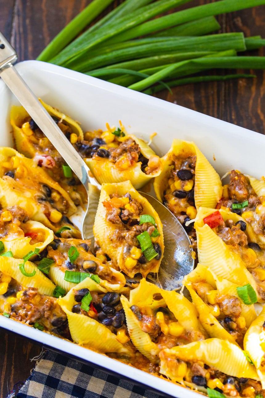 serving spoon scooping up a Taco Stuffed Shell