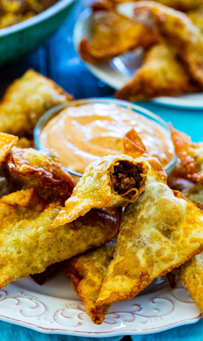 Taco Wontons on a plate with bowl of dipping sauce.