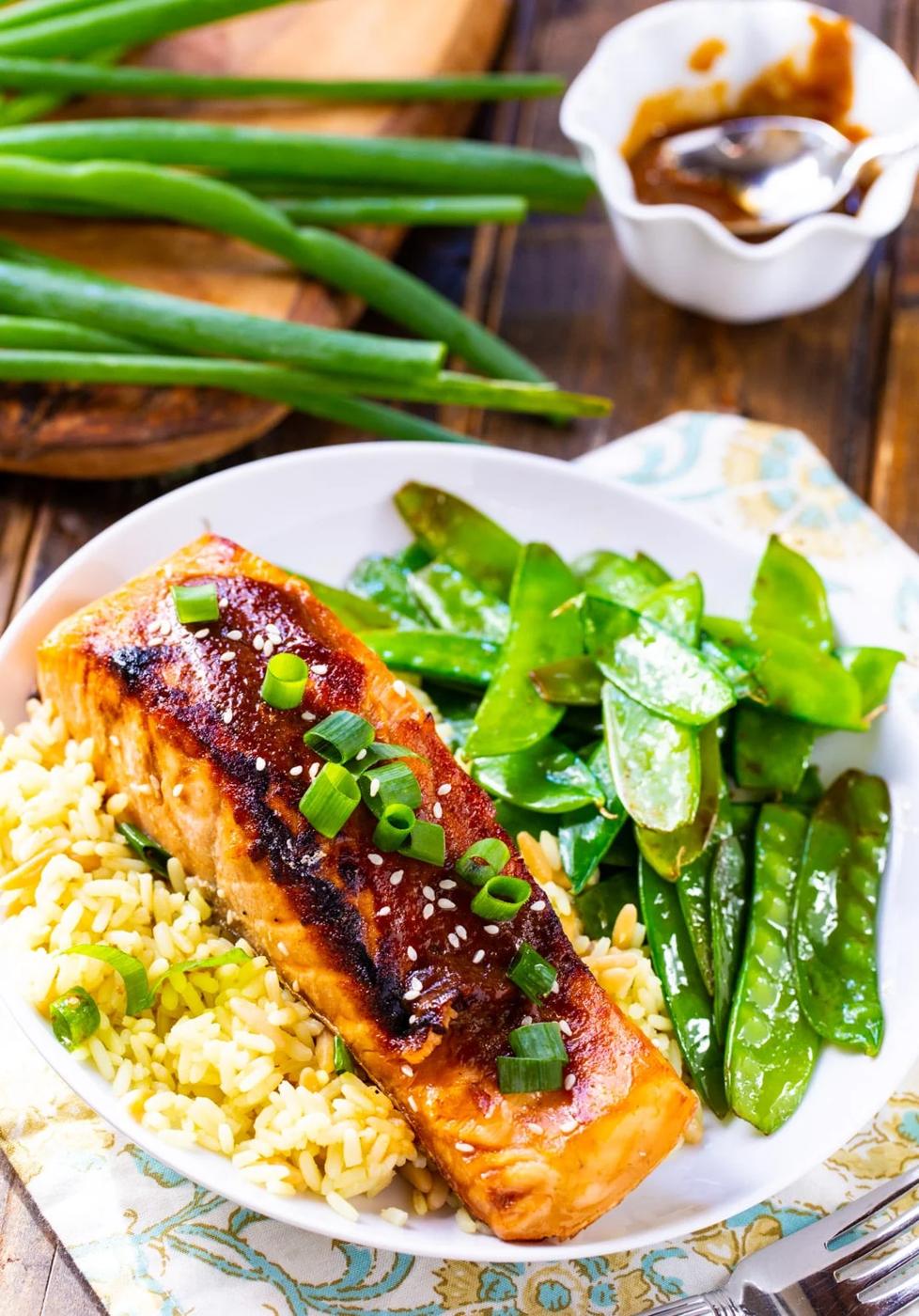 Salmon filet over rice with side of snow peas.