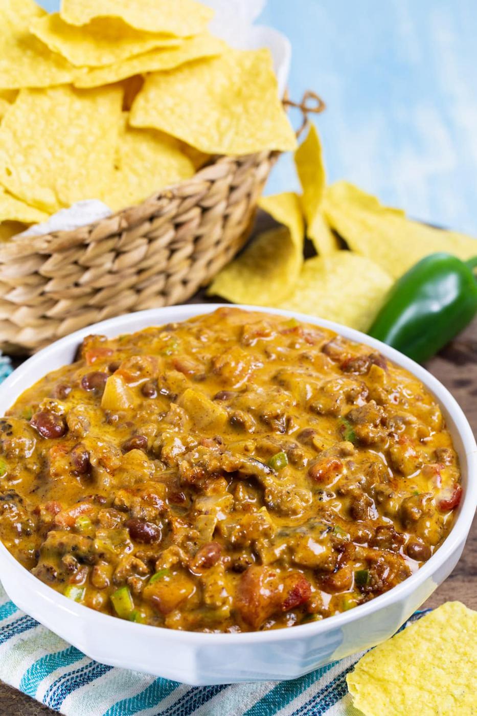 Chili Cheese Dip in a bowl and basket full of chips.