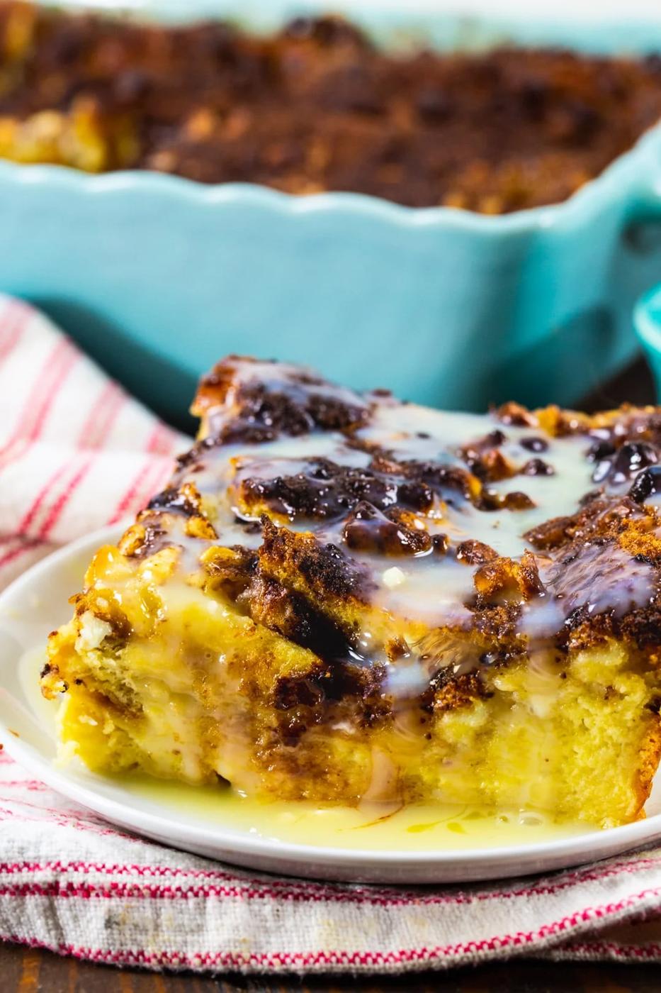 Slice of White Chocolate Bread Pudding on a plate with white chocolate sauce.
