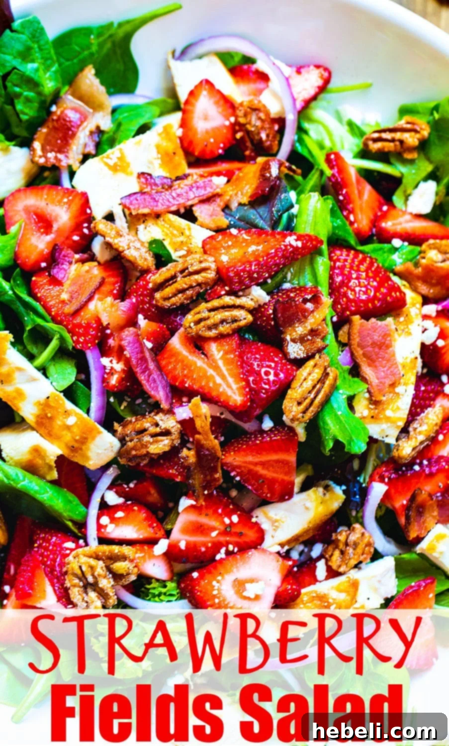 Full view of Strawberry Fields Salad, rich in color and texture, with feta, bacon, and glazed pecans.