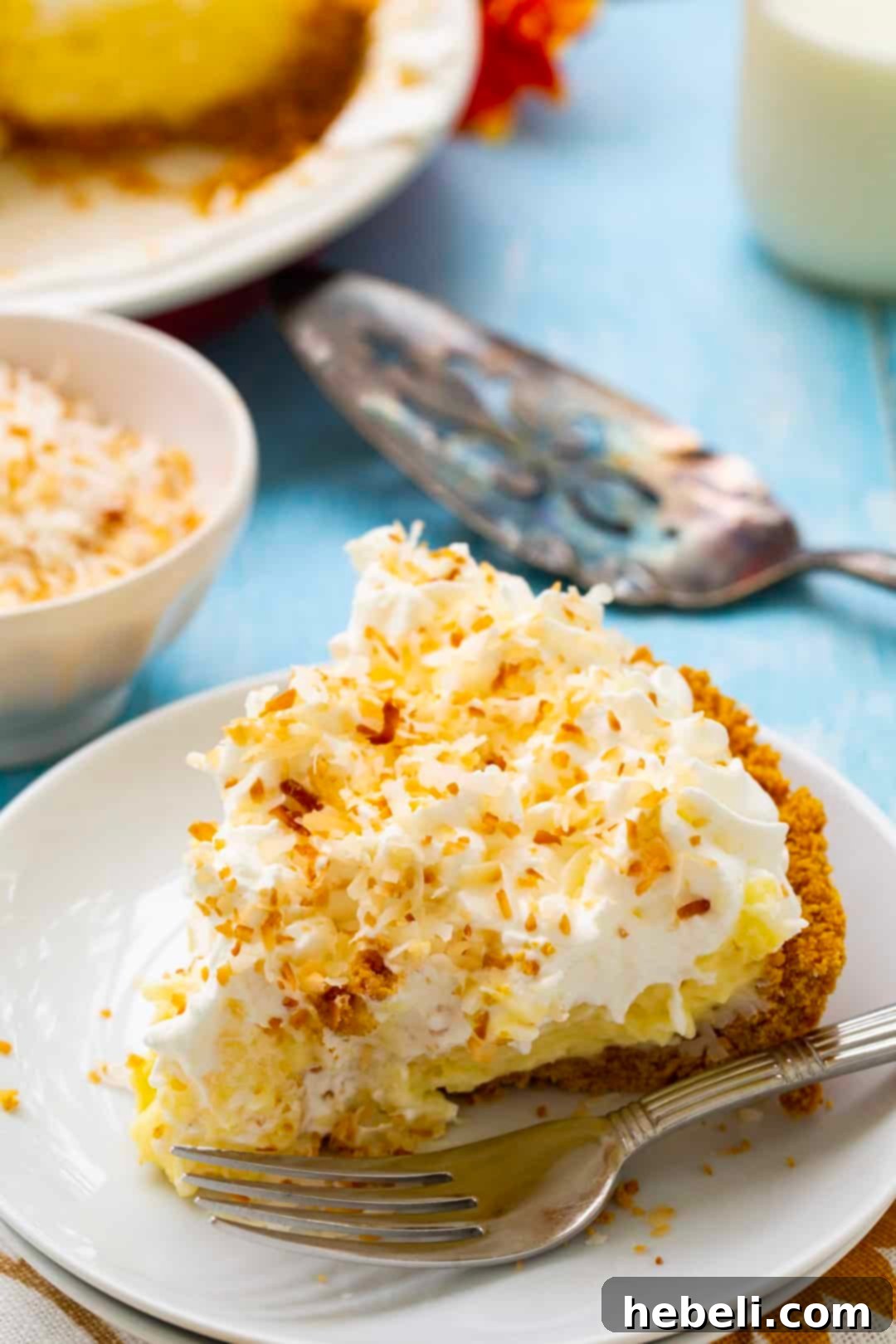 A delectable slice of Coconut Cream Pie on a plate, showcasing its creamy layers and perfectly toasted coconut garnish.