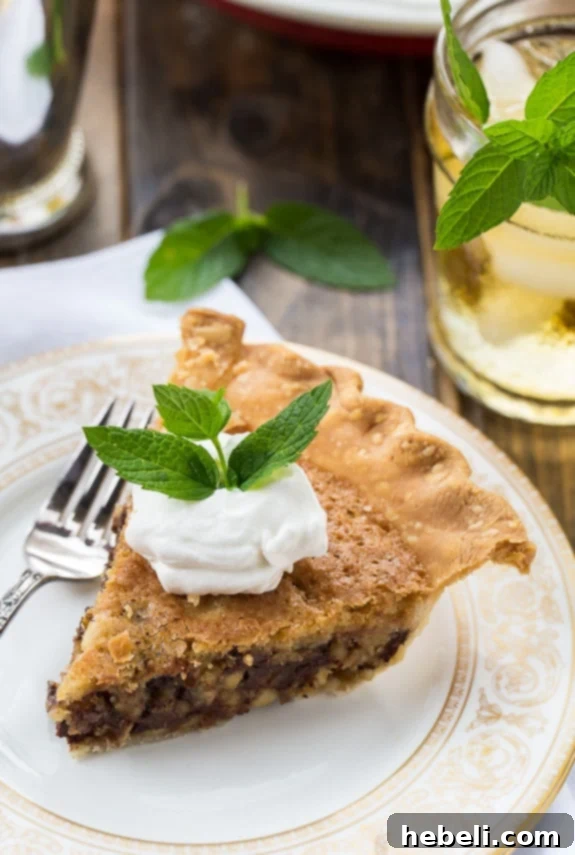 Close-up of Kentucky Derby Pie, highlighting the rich, dark chocolate and crunchy walnuts within its golden crust.