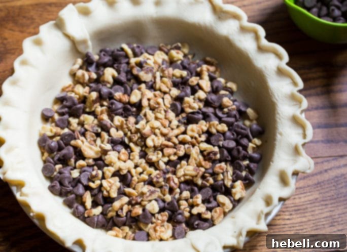 A whole Kentucky Derby Pie on a serving platter, ready to be sliced.