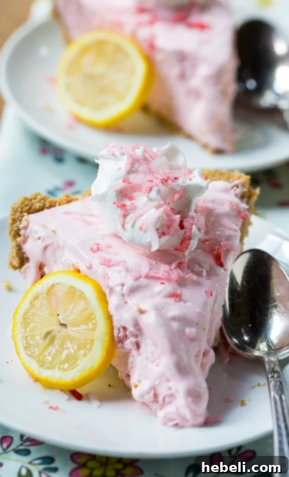 Pink Lemonade Icebox Pie garnished with tinted shredded coconut and a slice of lemon