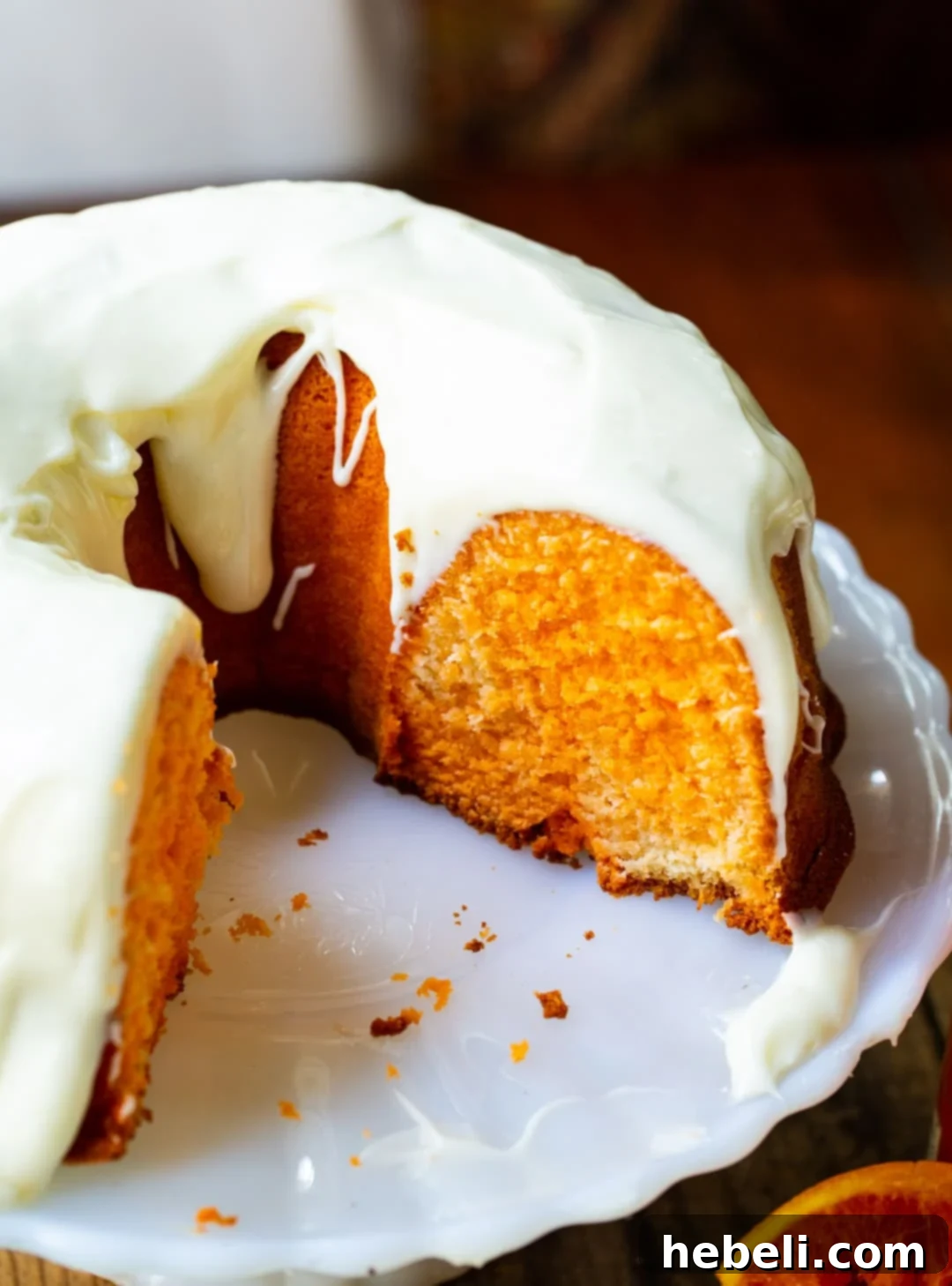 A beautifully frosted Fanta Pound Cake with Cream Cheese Frosting on a elegant cake stand.