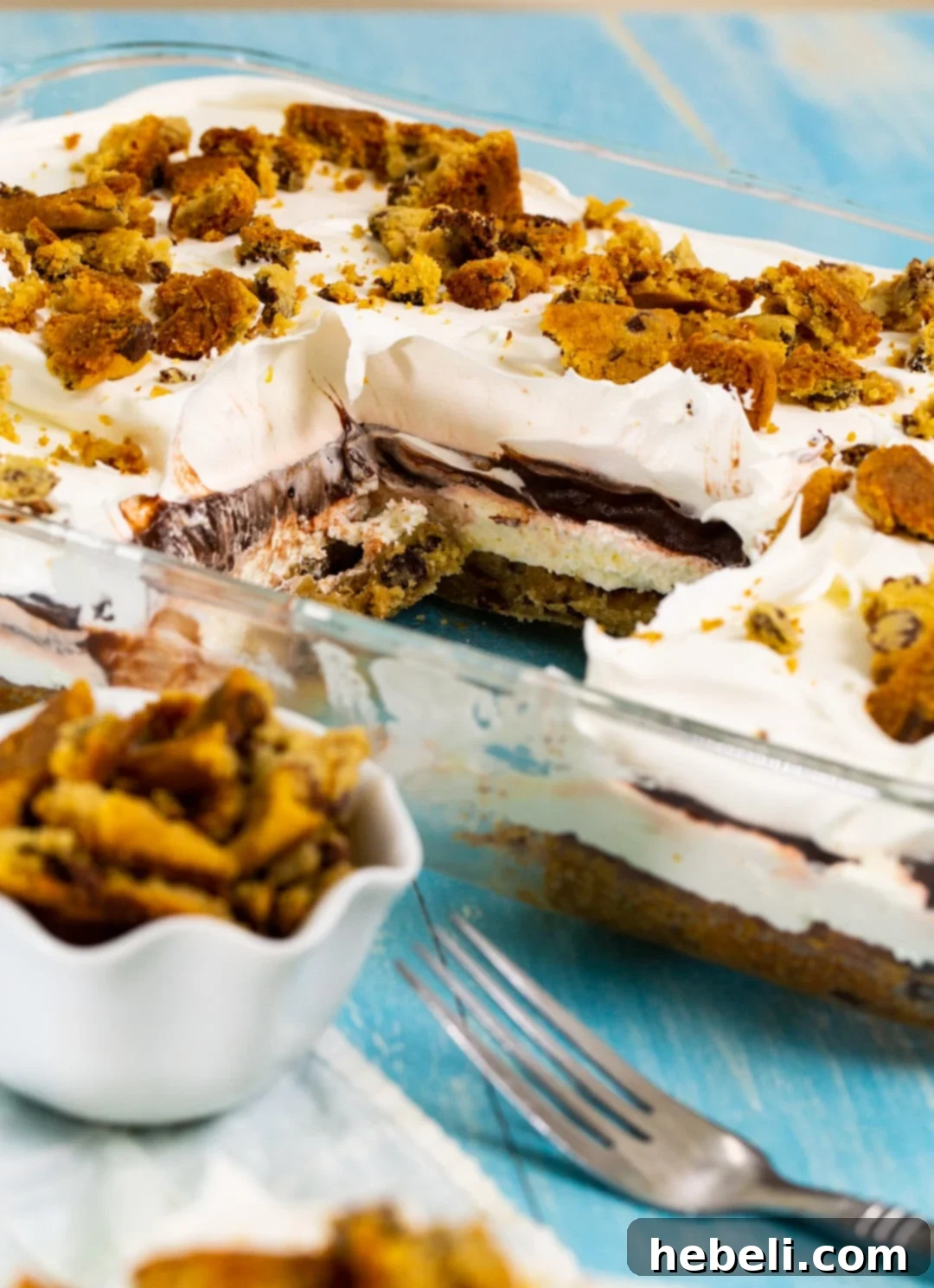 A slice of Chocolate Chip Cookie Delight cut out from the baking dish, showing all four delicious layers.