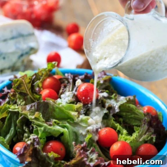Homemade Blue Cheese Vinaigrette on a fresh salad with cherry tomatoes and bacon