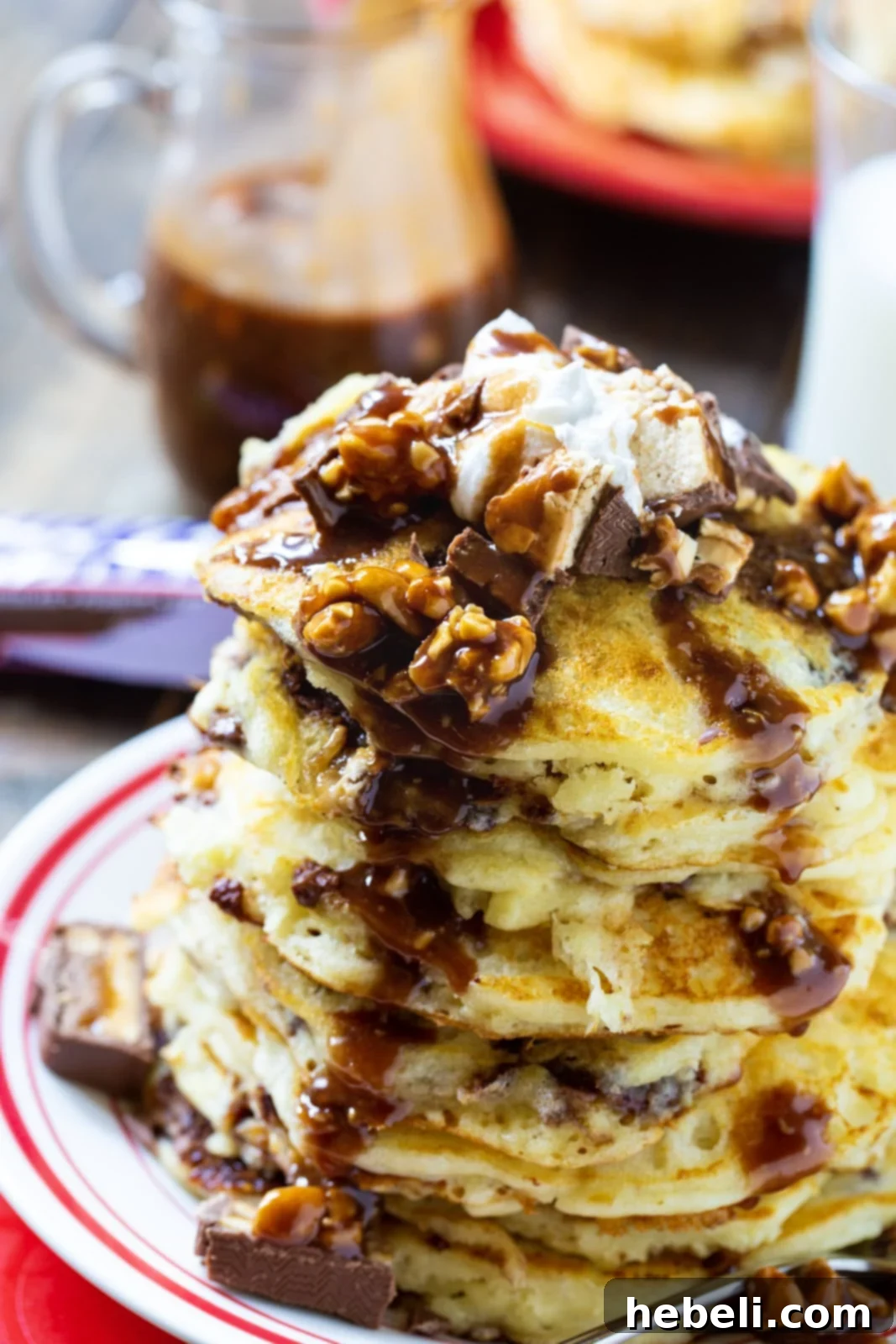 Stack of pancakes topped with snickers syrup.