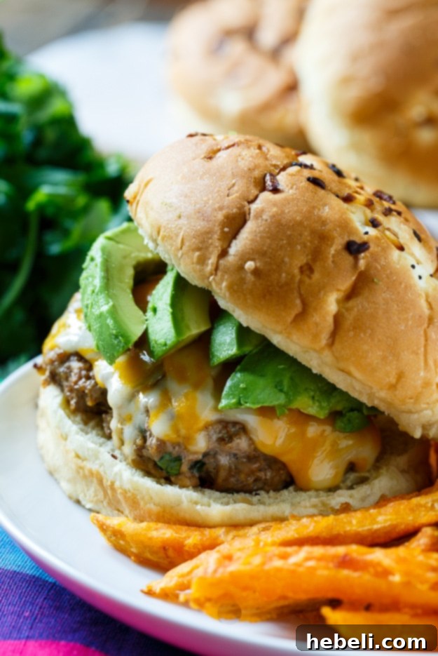 Smoky Chipotle Pork Burgers 3 Close-up of a Chipotle Pork Burger with melted cheese and avocado