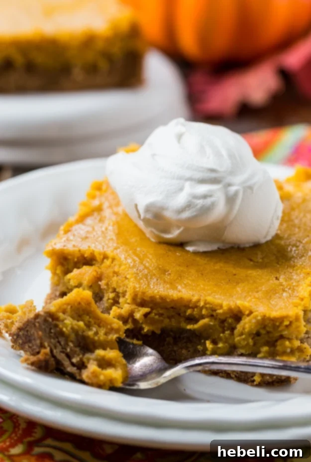 A close-up of the gooey pumpkin filling, highlighting its smooth texture and rich, autumnal color, promising a delicious bite.