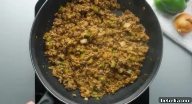 Sloppy Joe Mixture simmering in a pan, rich with ketchup and spices.