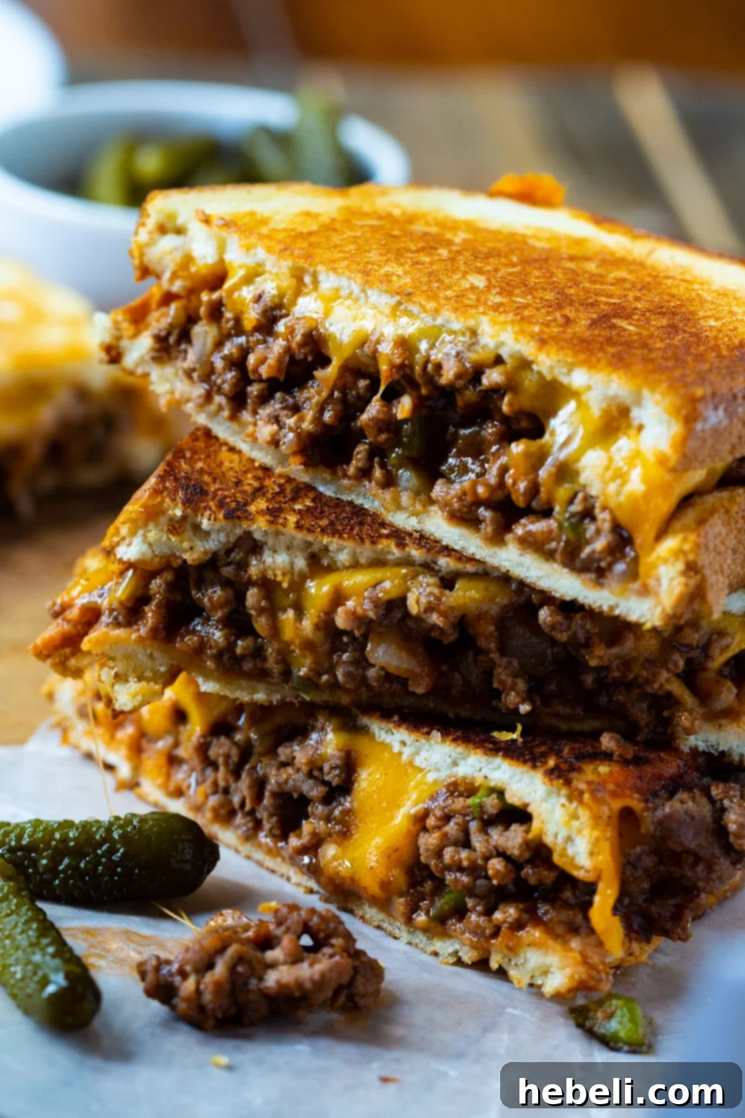 Grilled cheese halves stacked on top of each other, showcasing the golden-brown, crispy crust of the sandwich.