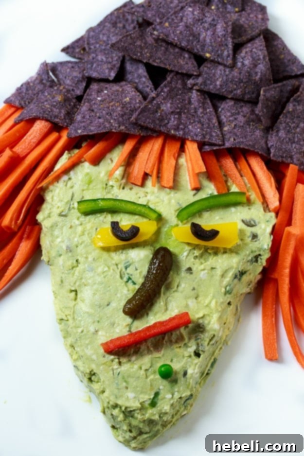 Witch's Brew Guacamole 6 Witch Guacamole Dip with carrot hair, tortilla chip hat, and bell pepper features.