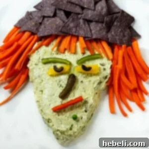 Witch's Brew Guacamole 7 A spooky yet delicious Witch Guacamole Dip, garnished with Halloween-themed vegetables.