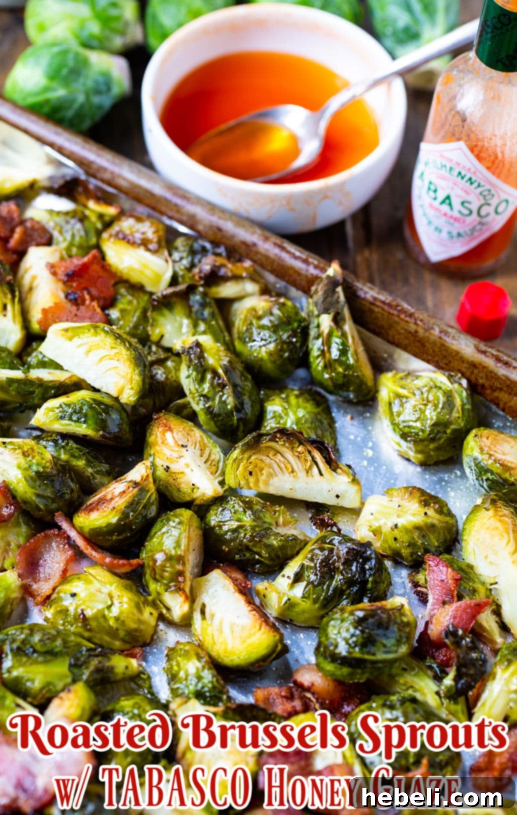 Close-up of Roasted Brussels Sprouts with Bacon and TABASCO Honey Glaze on a baking sheet, glistening and ready to be served.